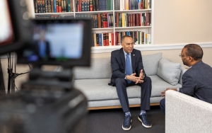 Hakeem Jeffries sits on a couch, talking with Troy McKenzie while a video camera films