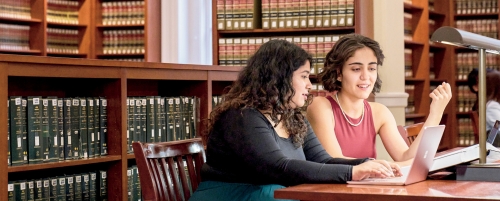Two students at a table in library