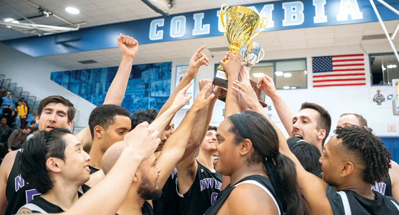 Student basketball players lifting up Dean's Cup