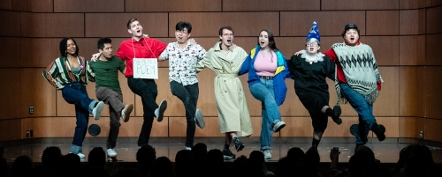 Students dancing on stage arm in arm.