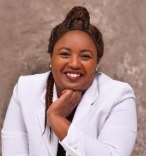 Black woman wearing a white suit smiling
