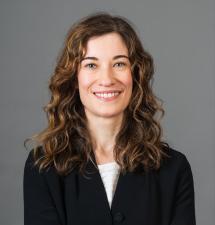 Person with mid-length curly hair smiling at the camera